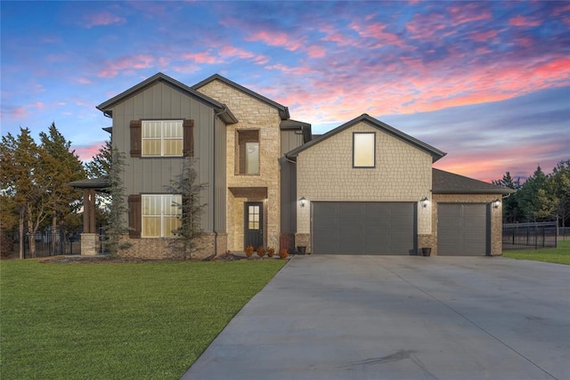 view of front of home with a garage and a lawn