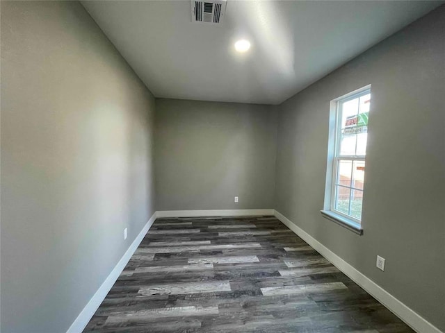 spare room with a wealth of natural light and dark hardwood / wood-style floors