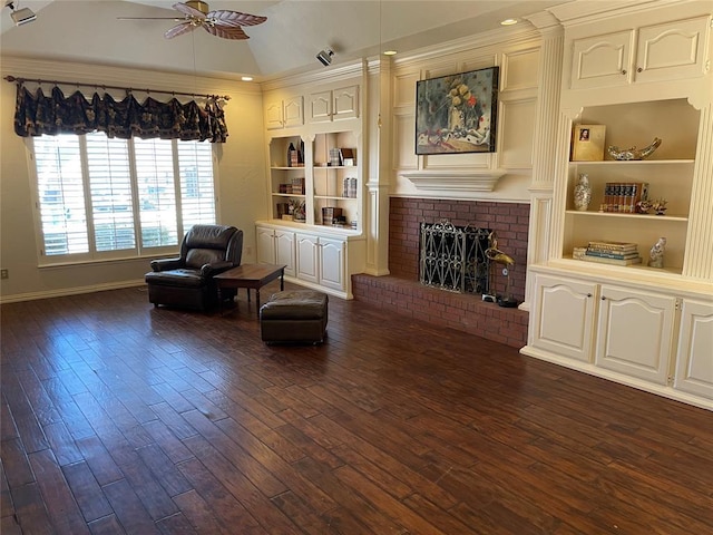 living area with a fireplace, vaulted ceiling, ceiling fan, dark hardwood / wood-style flooring, and crown molding