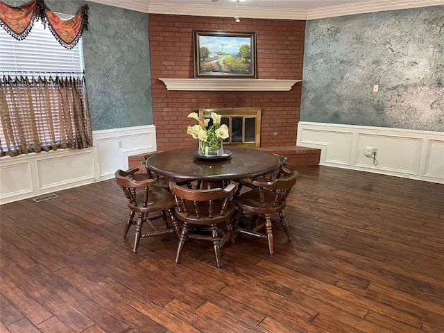 dining space with dark hardwood / wood-style flooring, a fireplace, and ornamental molding