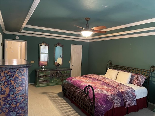 carpeted bedroom featuring a raised ceiling, ceiling fan, and crown molding