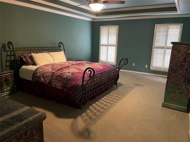 bedroom featuring multiple windows, ceiling fan, a tray ceiling, and crown molding