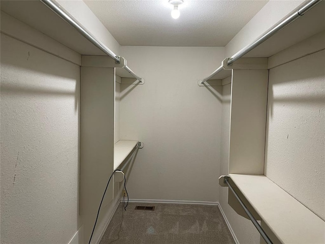 spacious closet featuring dark carpet