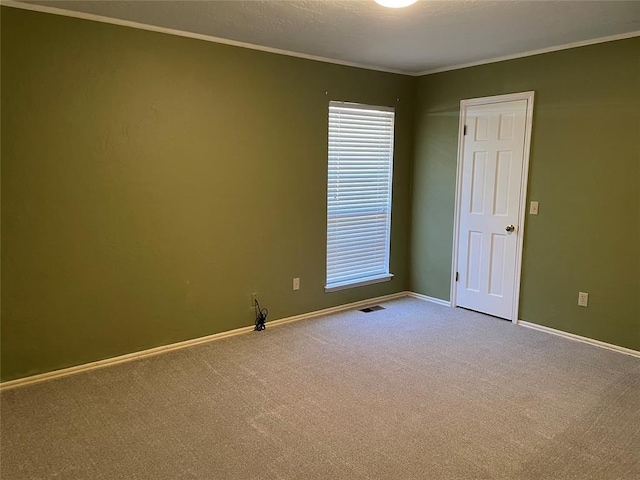 carpeted empty room featuring crown molding