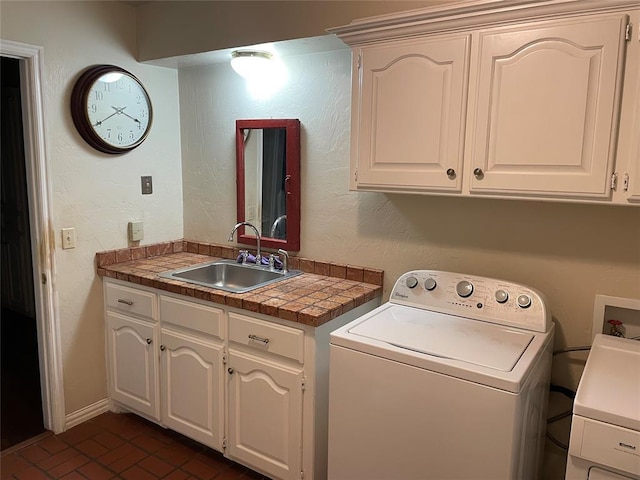 laundry room featuring independent washer and dryer, cabinets, and sink