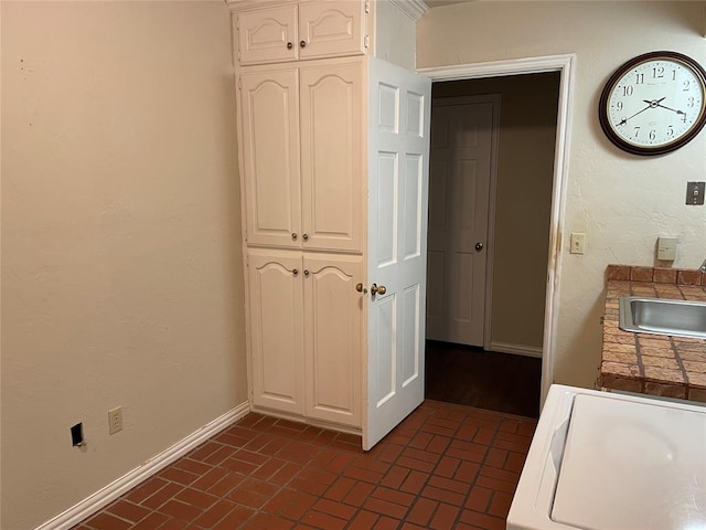 hall with washer / clothes dryer and sink