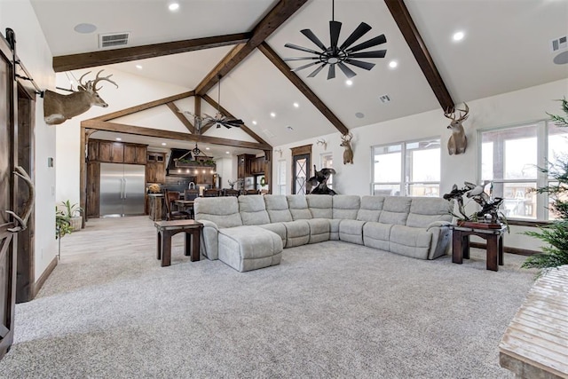 carpeted living room featuring a barn door, ceiling fan, beamed ceiling, and high vaulted ceiling