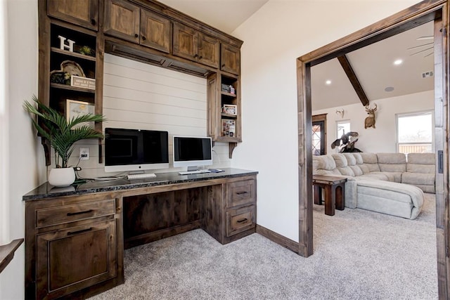 office area with lofted ceiling with beams, light colored carpet, and built in desk