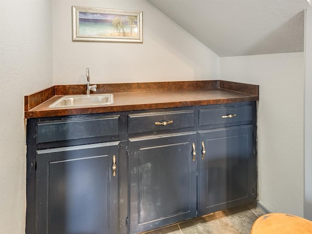 bathroom featuring lofted ceiling and sink