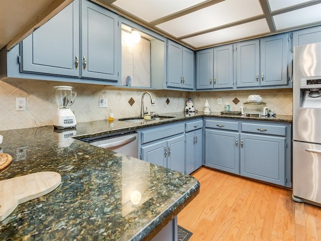 kitchen featuring blue cabinetry, appliances with stainless steel finishes, light wood-type flooring, and sink