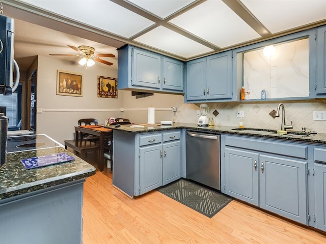 kitchen with kitchen peninsula, light wood-type flooring, blue cabinets, sink, and dishwasher