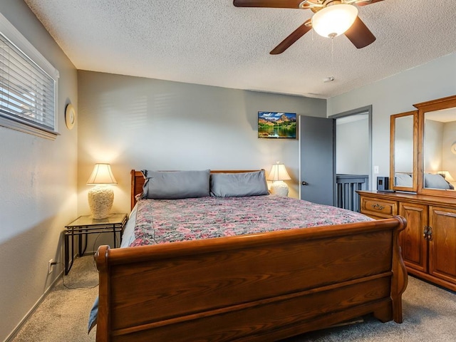 carpeted bedroom featuring a textured ceiling and ceiling fan