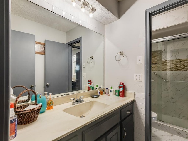 bathroom with a textured ceiling, vanity, and an enclosed shower