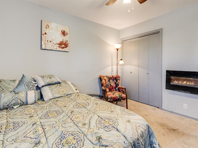 carpeted bedroom featuring a closet and ceiling fan