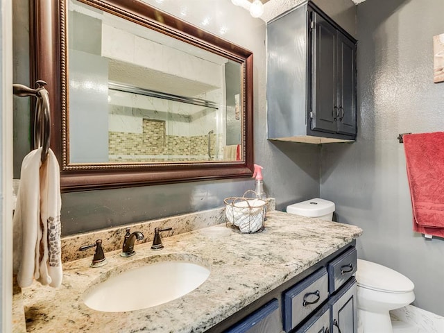 bathroom with vanity, toilet, and a shower with shower door