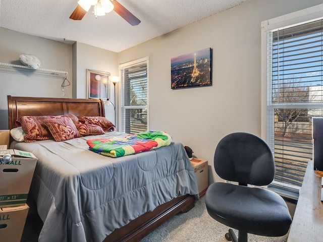 bedroom featuring ceiling fan, carpet floors, and a textured ceiling