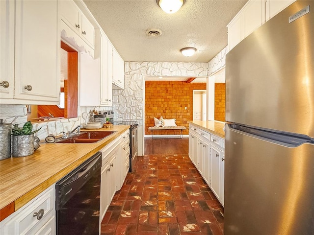 kitchen featuring wooden counters, stainless steel appliances, white cabinetry, and a textured ceiling