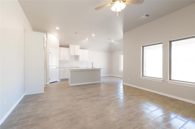 1917 Taines Turn, Norman, OK 73072 - unfurnished living room with a ceiling fan, baseboards, visible vents, and lofted ceiling