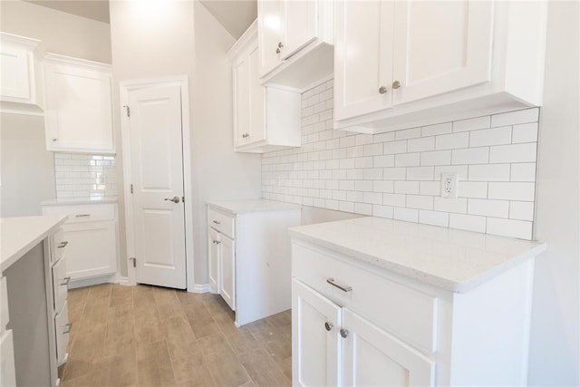 1917 Taines Turn, Norman, OK 73072 - kitchen with tasteful backsplash, light stone countertops, light wood-style flooring, and white cabinetry