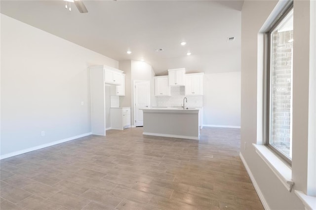 1917 Taines Turn, Norman, OK 73072 - unfurnished living room with ceiling fan, a sink, light wood-style floors, baseboards, and visible vents