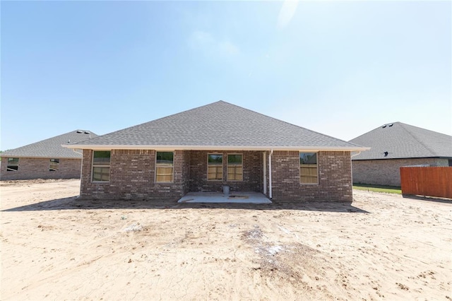 1917 Taines Turn, Norman, OK 73072 - rear view of property featuring a patio, roof with shingles, and brick siding