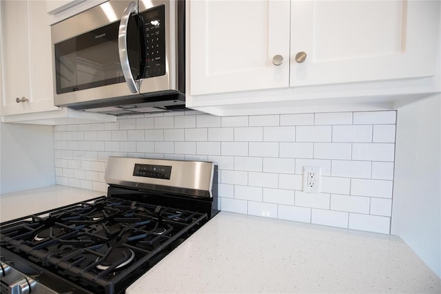 1917 Taines Turn, Norman, OK 73072 - kitchen with stainless steel appliances, white cabinets, decorative backsplash, and light stone countertops