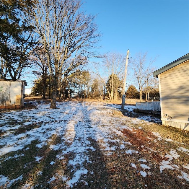 yard layered in snow featuring an outbuilding