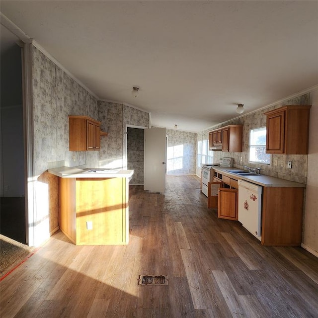 kitchen with white appliances, wood finished floors, brown cabinets, wallpapered walls, and crown molding