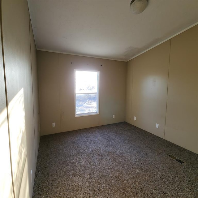 unfurnished room featuring carpet floors, ornamental molding, and visible vents