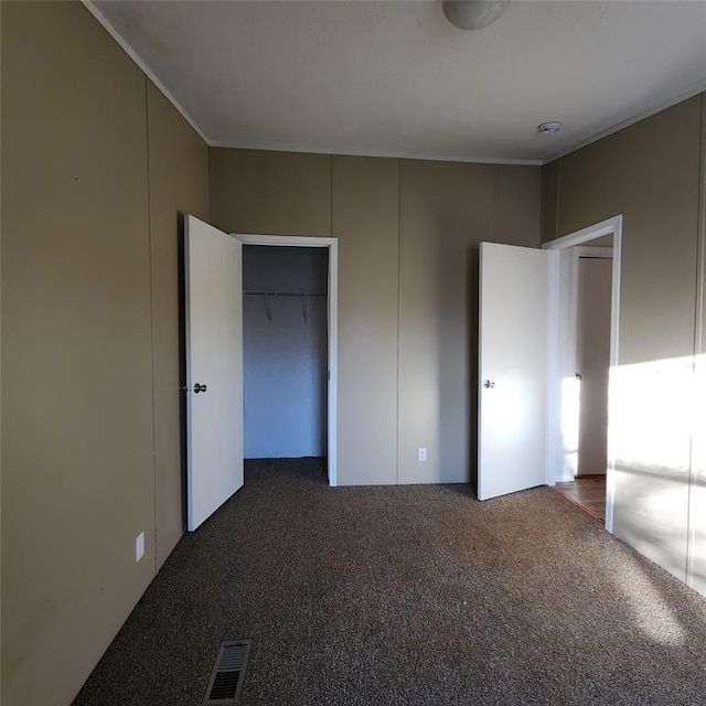 unfurnished bedroom with carpet floors, a closet, and visible vents