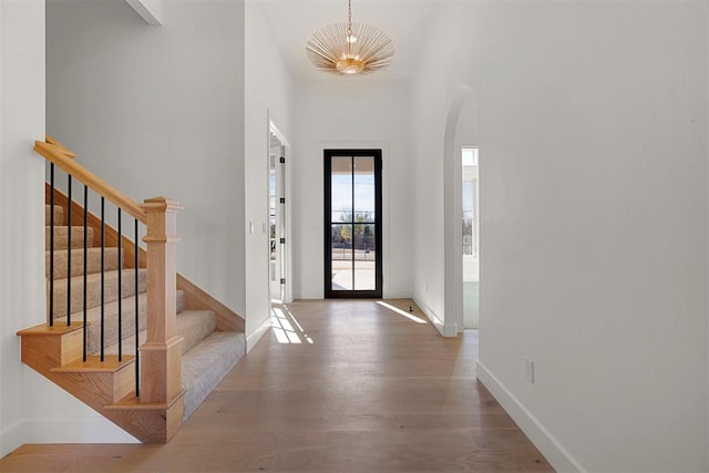 entrance foyer featuring dark wood-type flooring, a high ceiling, and a chandelier