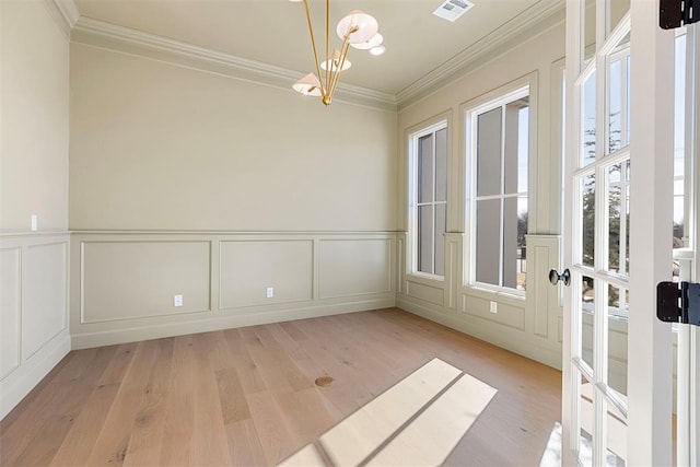 interior space with crown molding, light wood-type flooring, and a notable chandelier