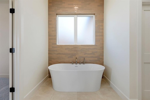 bathroom with tile patterned flooring and a bath