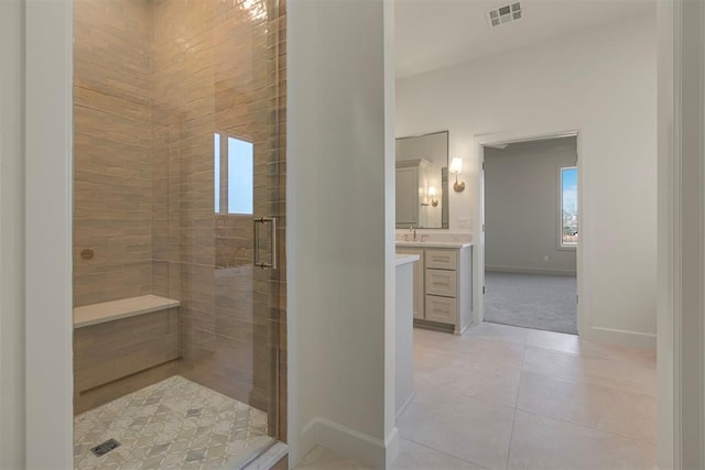 bathroom featuring tile patterned floors, a shower with door, and vanity