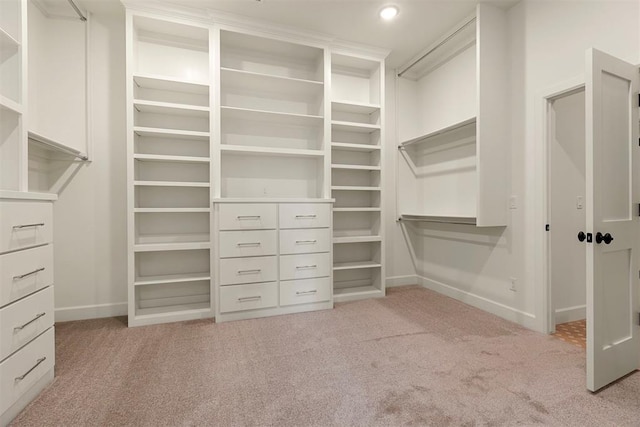 walk in closet featuring light carpet