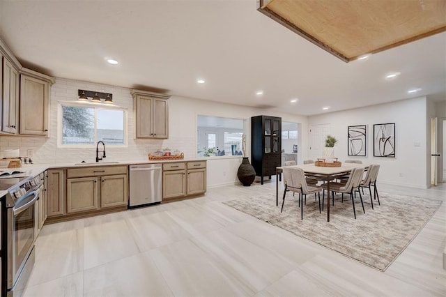 kitchen with decorative backsplash, sink, stainless steel appliances, and light brown cabinetry