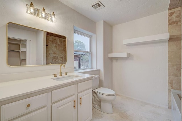 bathroom with vanity, a textured ceiling, and toilet