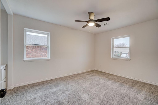 carpeted spare room with ceiling fan