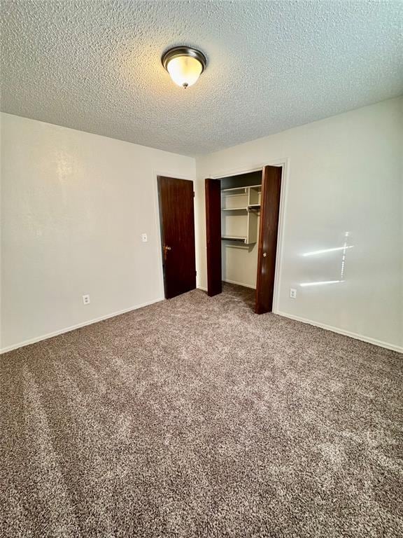 unfurnished bedroom featuring carpet flooring, a textured ceiling, and a closet