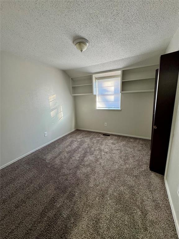 unfurnished bedroom featuring carpet flooring and a textured ceiling