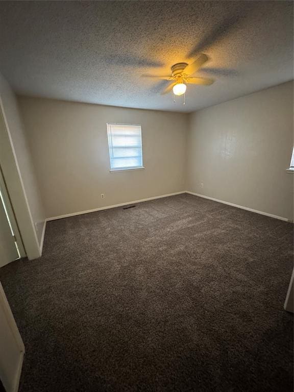 carpeted spare room with ceiling fan and a textured ceiling