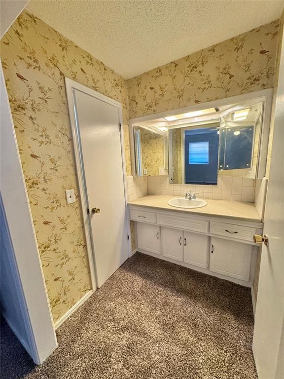 bathroom with vanity, a textured ceiling, and backsplash