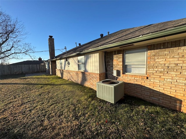 view of side of home featuring a lawn and cooling unit