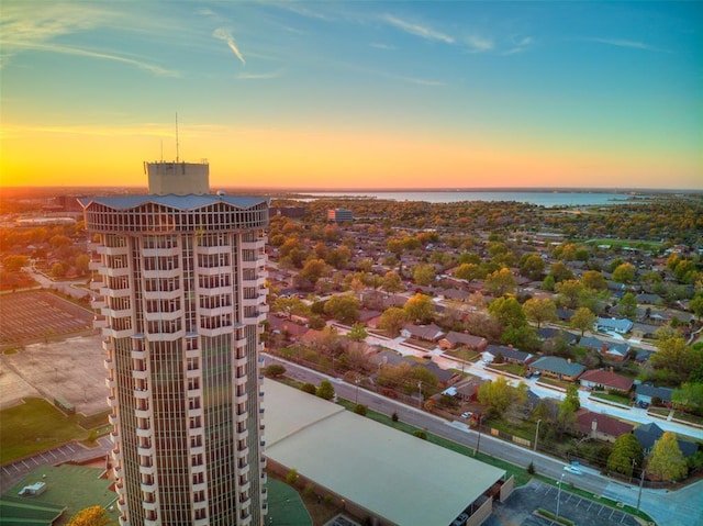 aerial view at dusk featuring a water view