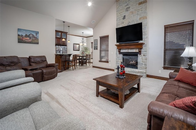 living area featuring high vaulted ceiling, light carpet, a stone fireplace, and baseboards