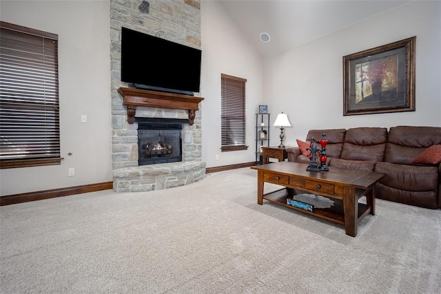 living room with a stone fireplace, light colored carpet, and high vaulted ceiling