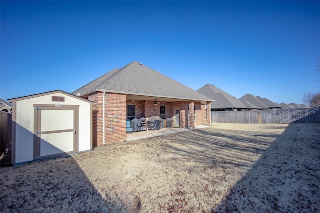 rear view of property with a shed, ceiling fan, and a patio area