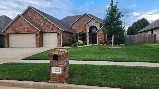 view of front facade with brick siding, concrete driveway, fence, a garage, and a front lawn