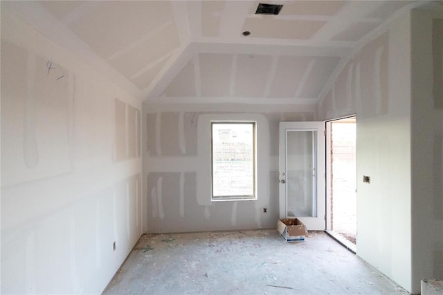 spare room featuring lofted ceiling and visible vents