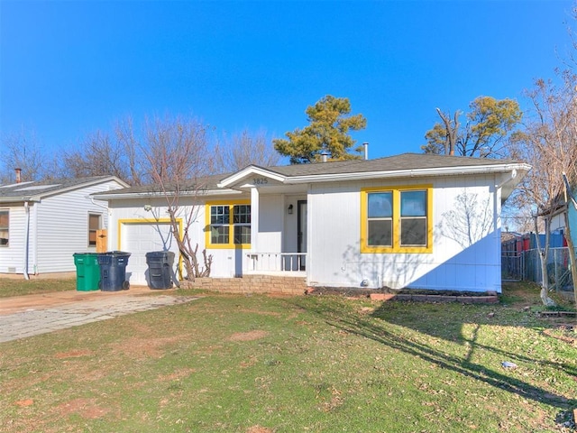 ranch-style home featuring covered porch, a garage, and a front lawn